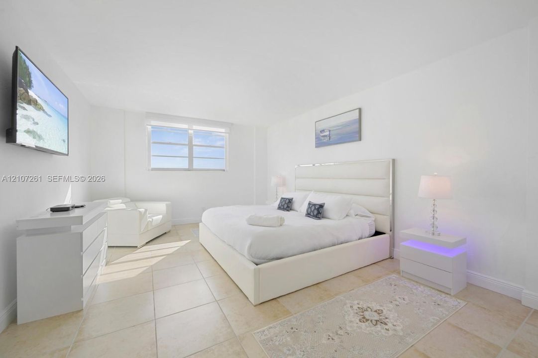 Neutral-toned tile flooring, minimalist white walls, and a multi-pane window