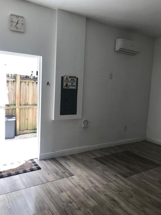 Wood-finish flooring, wall-mounted ductless climate control unit, and recessed electrical panel