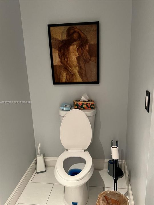 Ceramic tile flooring and white porcelain toilet