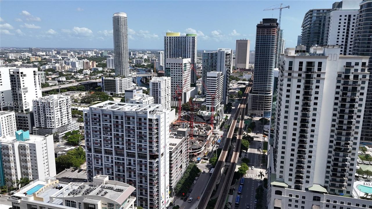 High-rise urban landscape featuring numerous multi-story residential towers, dense metropolitan architecture, and an elevated transit corridor