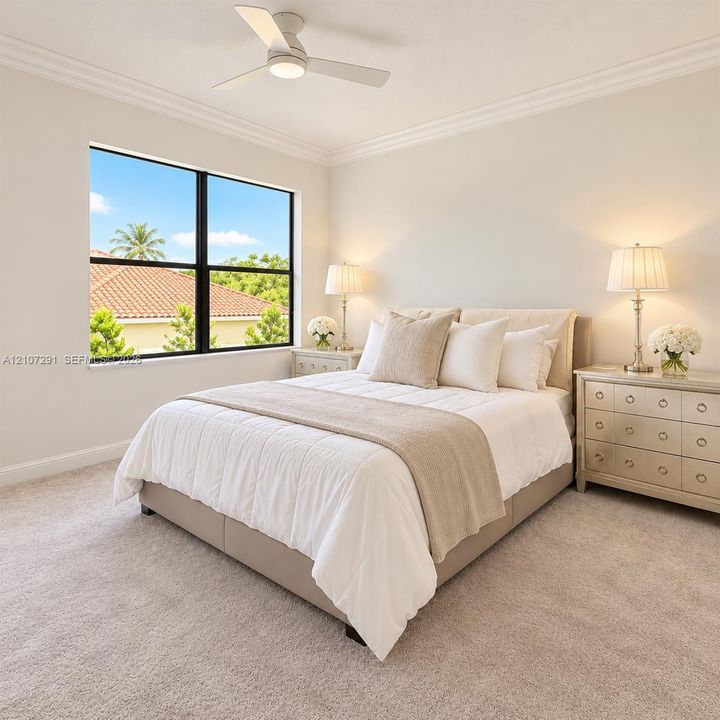 Neutral interior featuring crown molding, neutral carpeting, a central ceiling fan with integrated lighting, and a large window with black framing