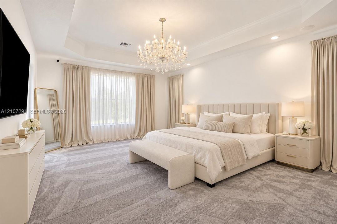 Tray ceiling with recessed lighting, tiered crystal chandelier, and wall-to-wall carpeting
