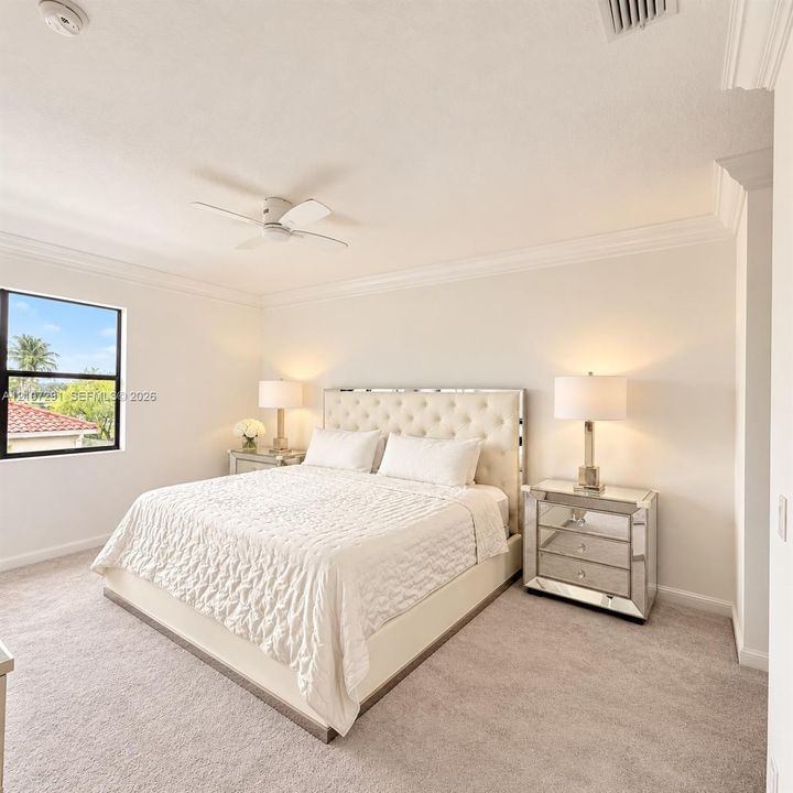 Neutral-toned interior space featuring crown molding, carpeting, and a ceiling fan