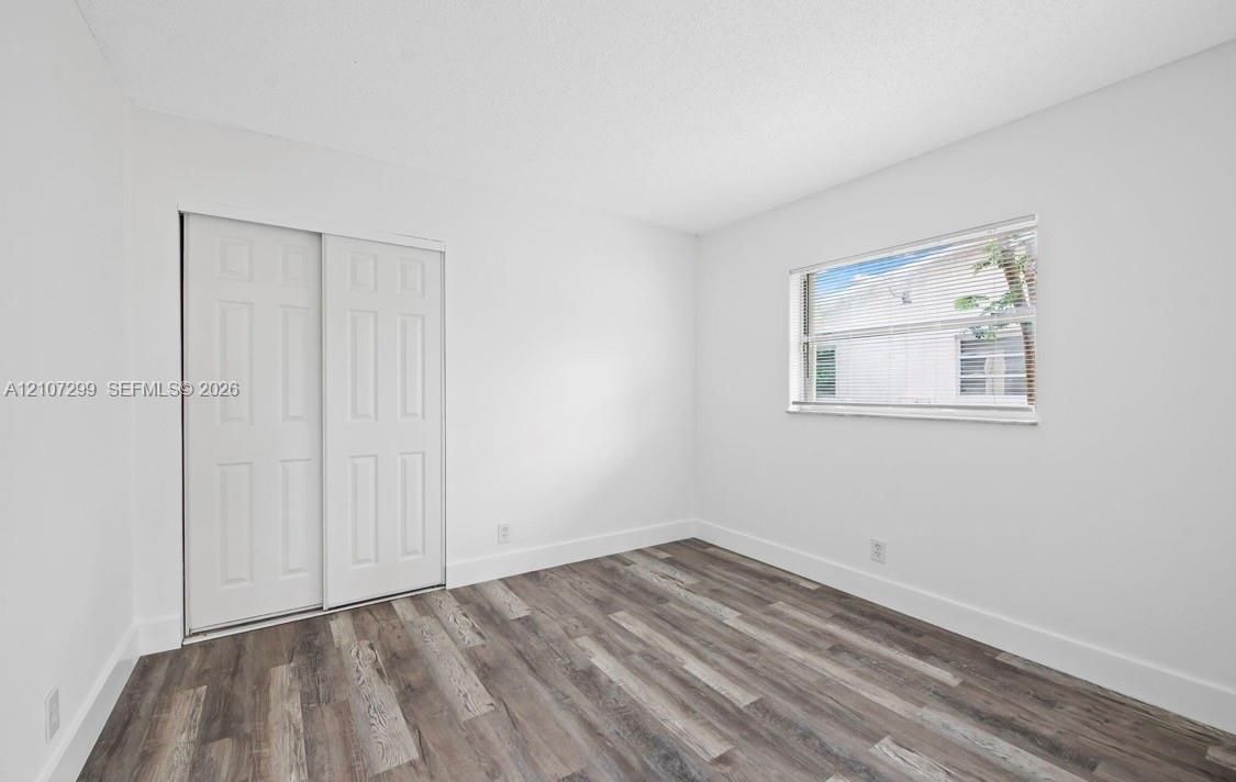 Wood-finish flooring, sliding closet doors, and a rectangular window