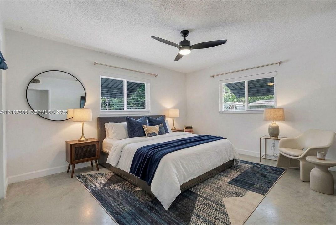 Interior space featuring concrete flooring, dual horizontal sliding windows, and a matte black ceiling fan with an integrated light fixture