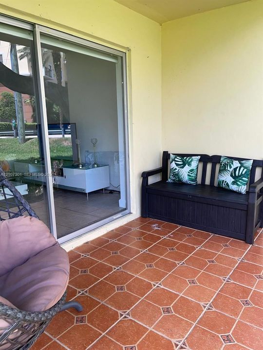 Covered patio featuring terracotta-style tile flooring and sliding glass door access