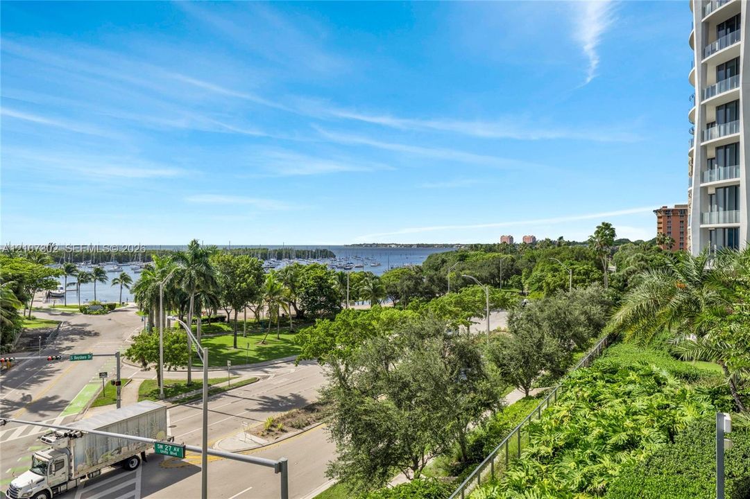 Elevated balcony featuring glass railings, unobstructed waterfront exposure, and expansive coastal landscape