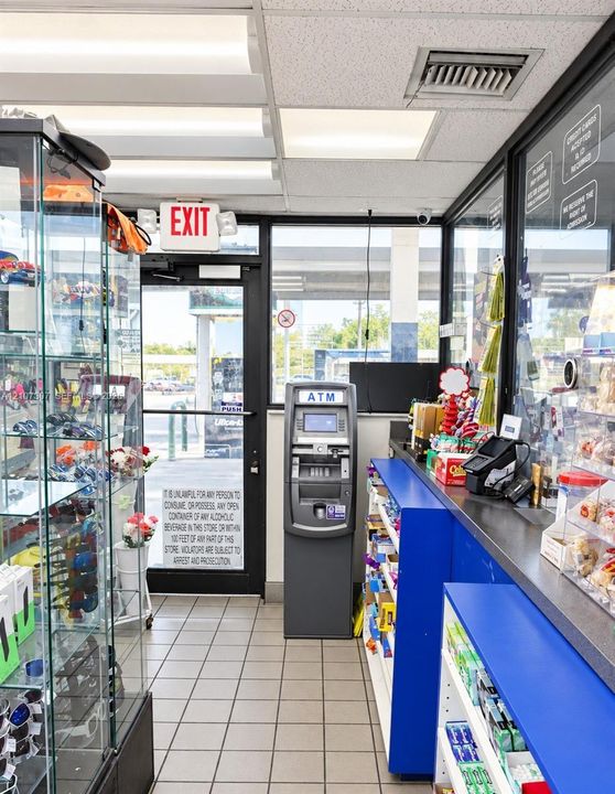 Commercial space featuring tile flooring, floor-to-ceiling glass paneling, built-in service counter, and overhead fluorescent lighting
