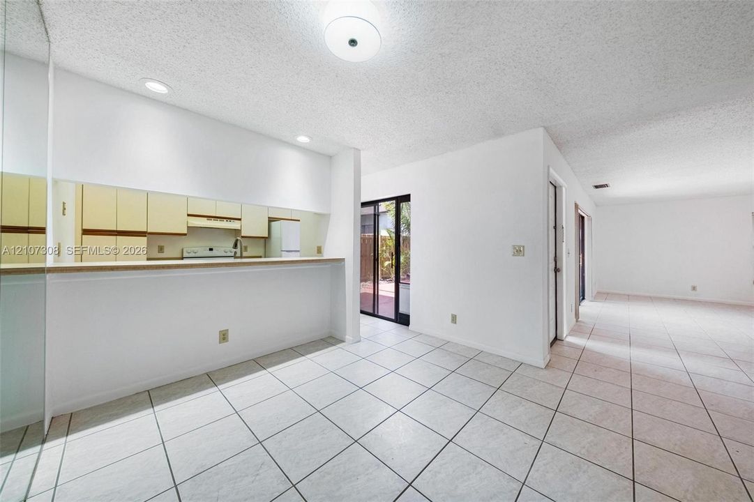 Tile flooring, kitchen pass-through with flat-surface ledge, and sliding glass door