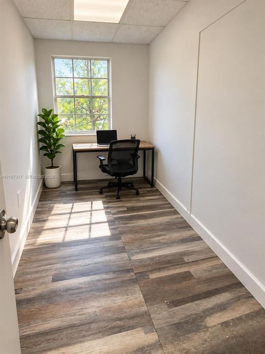 Interior space featuring wood-finish flooring, a multi-pane window, and a recessed ceiling light fixture