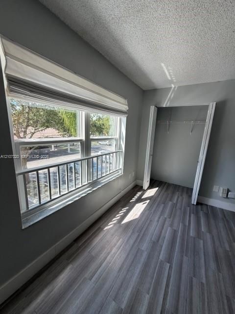 Wood-finish flooring, large window with integrated metal security bar, and built-in closet with double doors