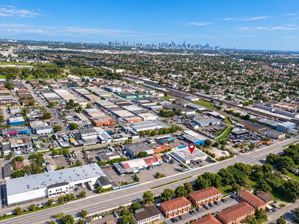 Aerial perspective of commercial property featuring direct street access, paved parking area, and multi-bay building configuration