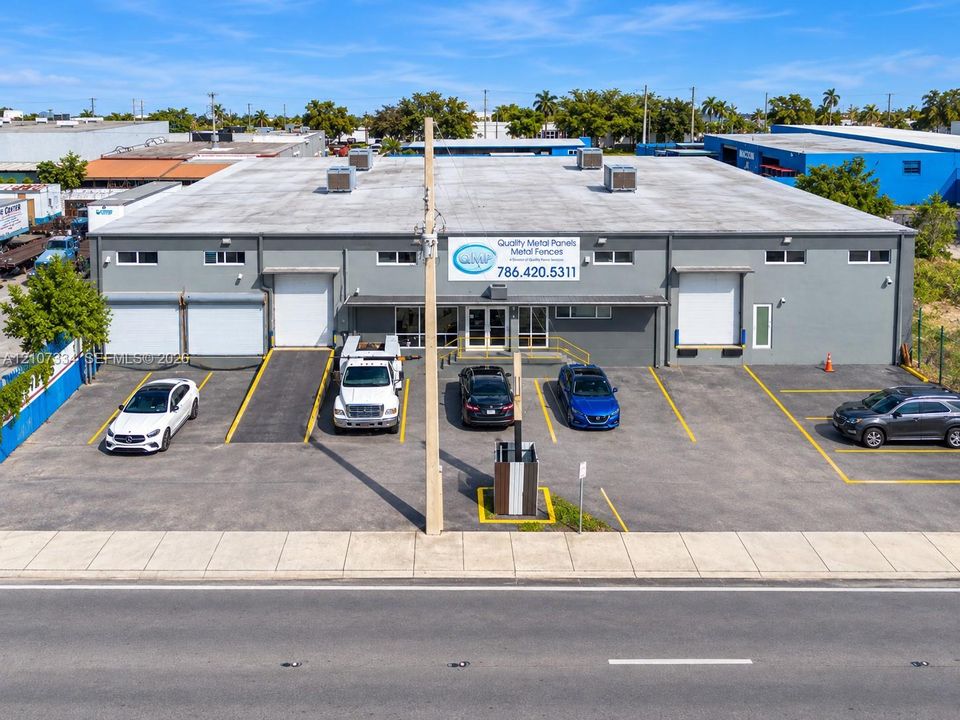 Industrial facility featuring a reinforced concrete exterior, dual grade-level loading bays, dedicated ramp access, and a paved surface parking lot