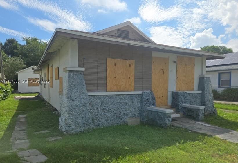 Single-story bungalow featuring a covered front porch, stone-veneer foundation, and gable roof