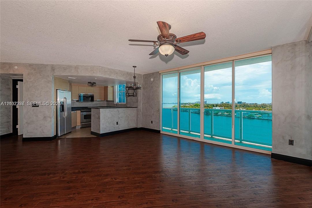 Wood-finish flooring, floor-to-ceiling glass wall, ceiling fan, and peninsula kitchen counter