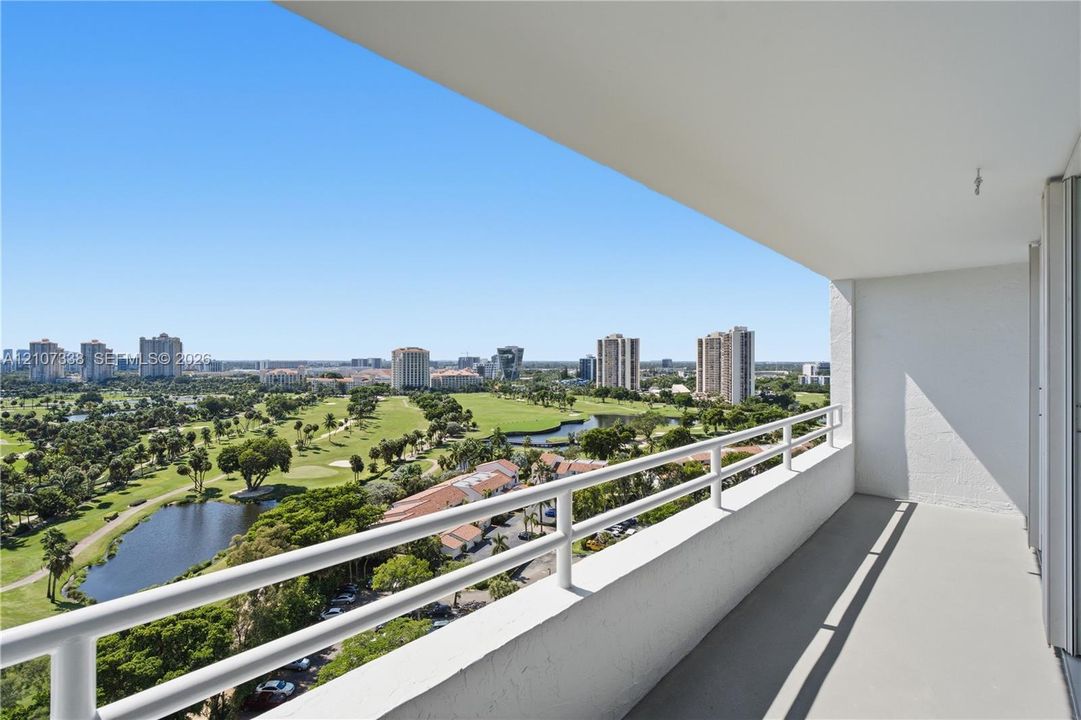 Covered balcony with white metal railings, concrete flooring, and unobstructed exterior exposure