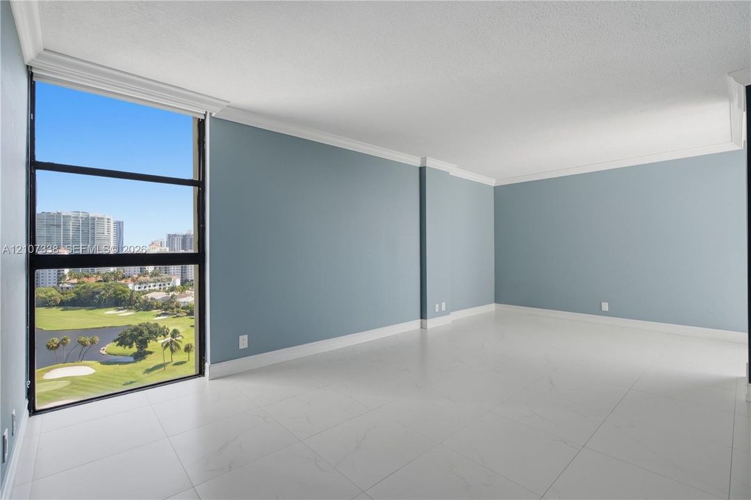 Floor-to-ceiling windows, large-format tile flooring, crown molding, and neutral wall tones