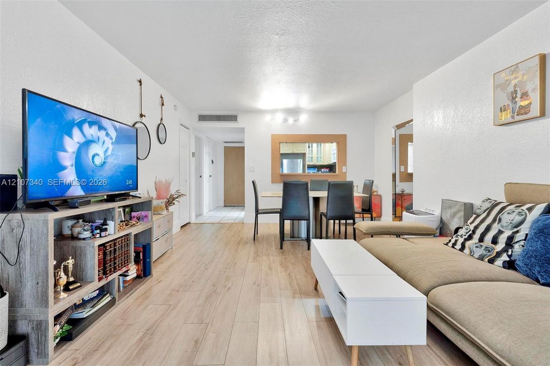 Interior space featuring wood-finish flooring, smooth-textured walls, and a recessed pass-through window with wooden trim