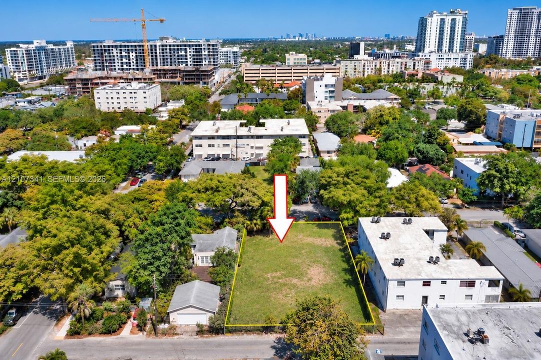 Vacant rectangular lot featuring level topography, perimeter fencing, and mature canopy trees