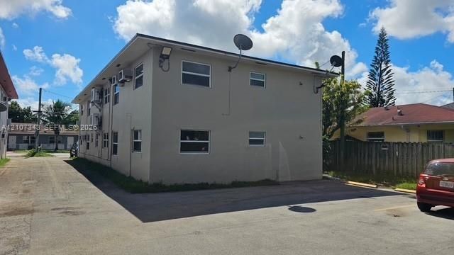 Two-story multi-unit structure featuring a concrete exterior, asphalt-shingle roof, and dedicated surface parking