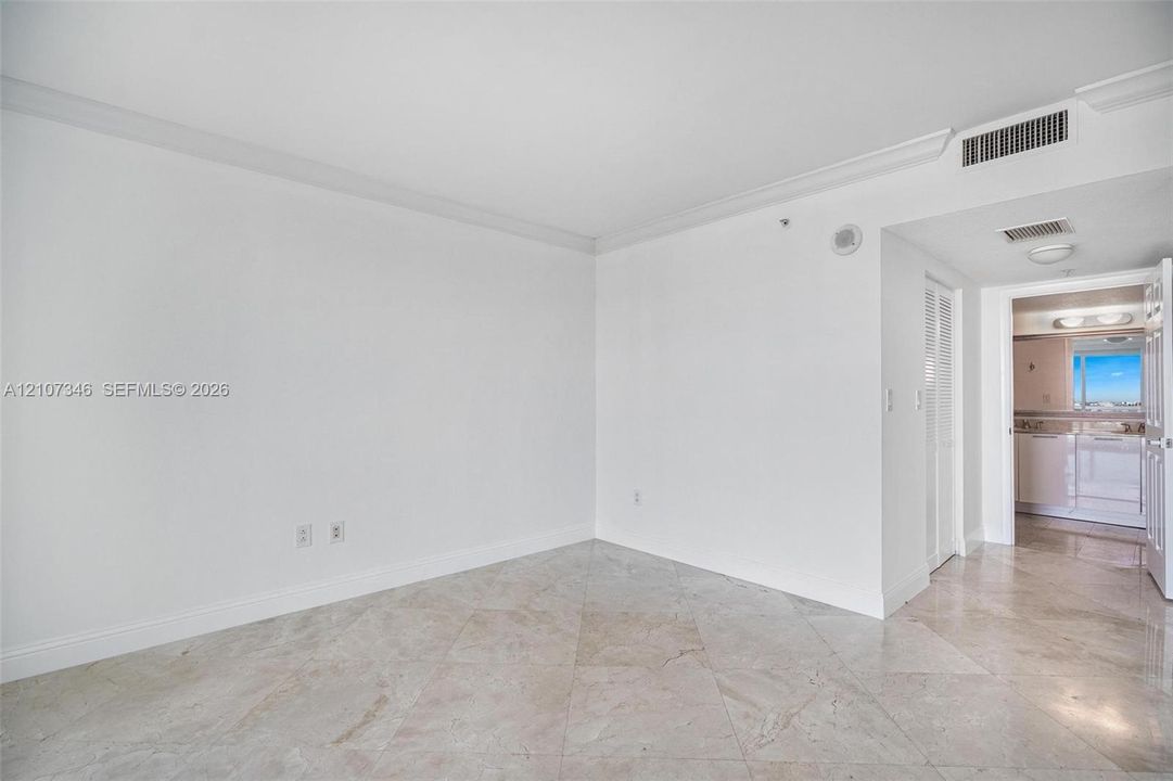 Neutral-toned flooring, crown molding, and high ceilings