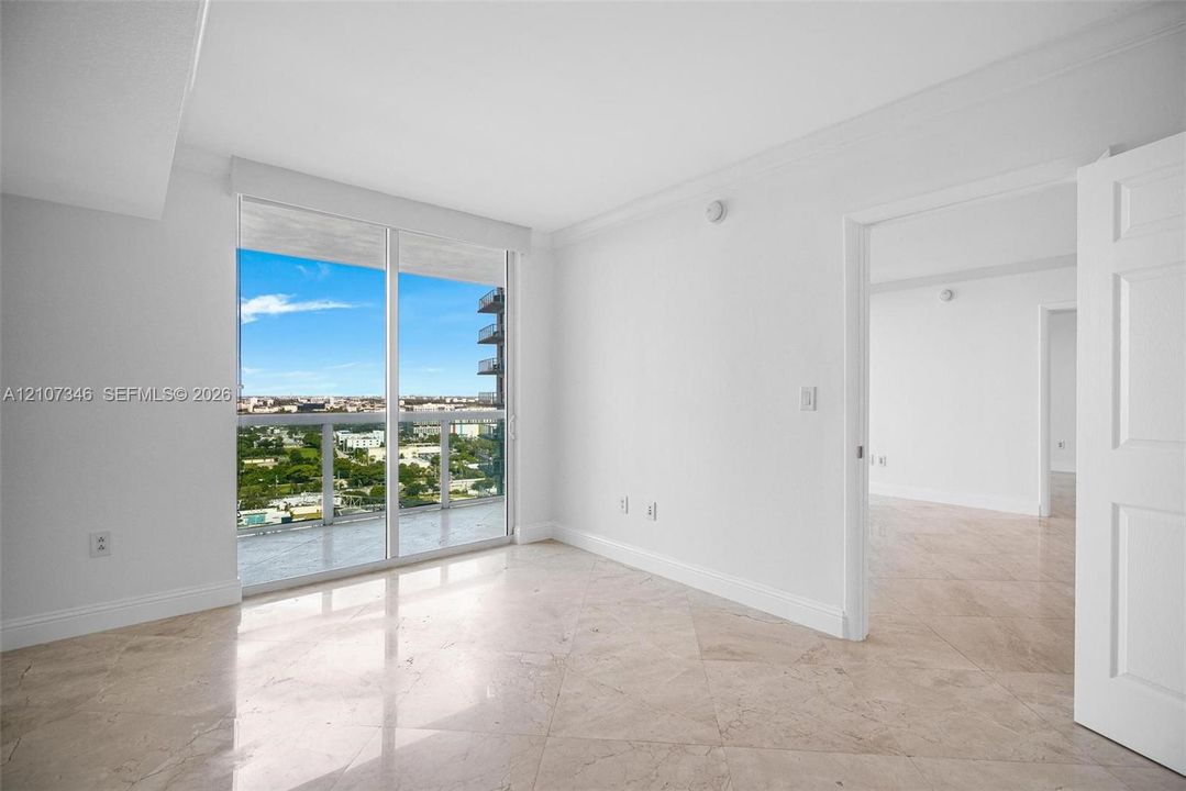 Floor-to-ceiling glass windows, polished stone flooring laid in a diamond pattern, and expansive urban scenery