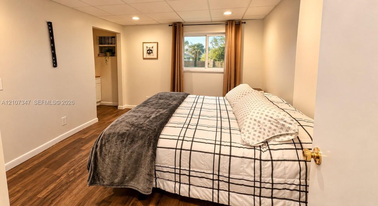 Room featuring wood-finish flooring, recessed lighting, and a drop ceiling