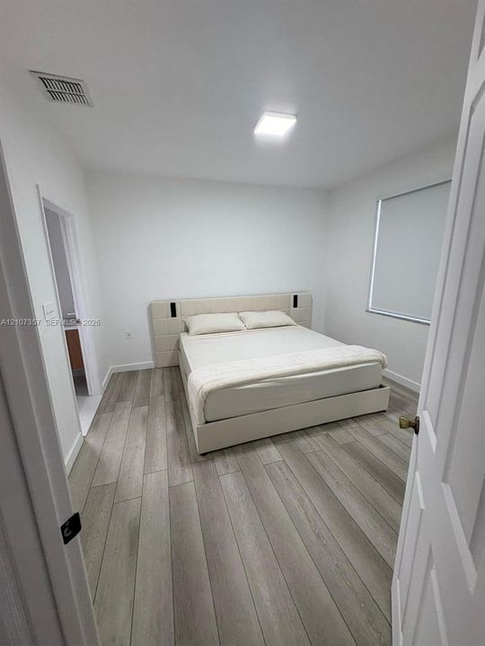 Wood-finish flooring, neutral walls, and recessed ceiling lighting