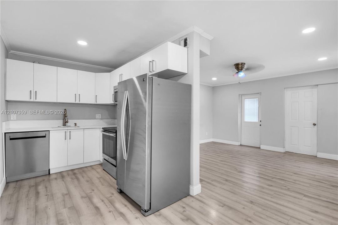 Additional kitchen view showcasing ample counter space, stainless-steel appliances, and the open layout.