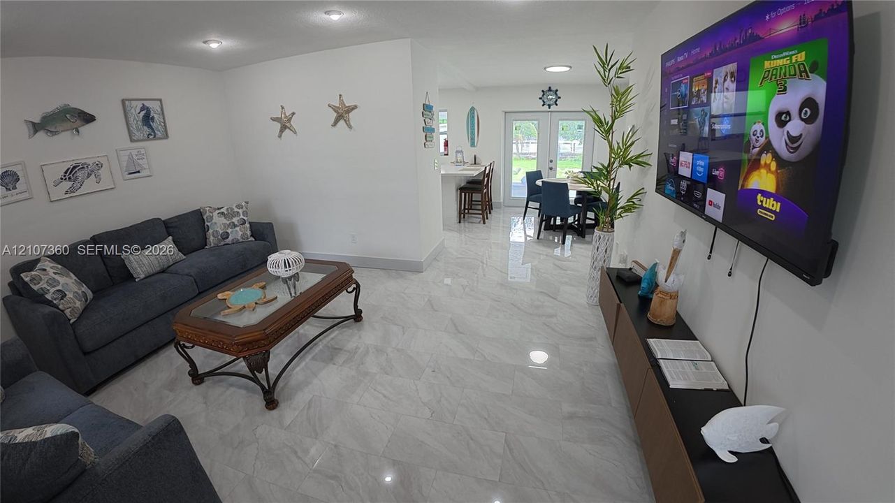Large-format tile flooring, recessed ceiling lighting, and double-door access to an exterior space