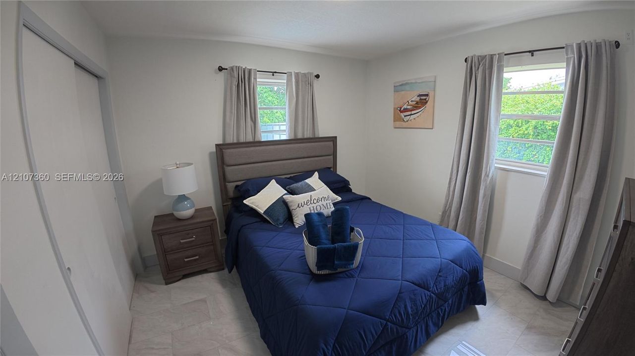 Neutral-toned walls, stone-finish tile flooring, and dual windows with natural light exposure