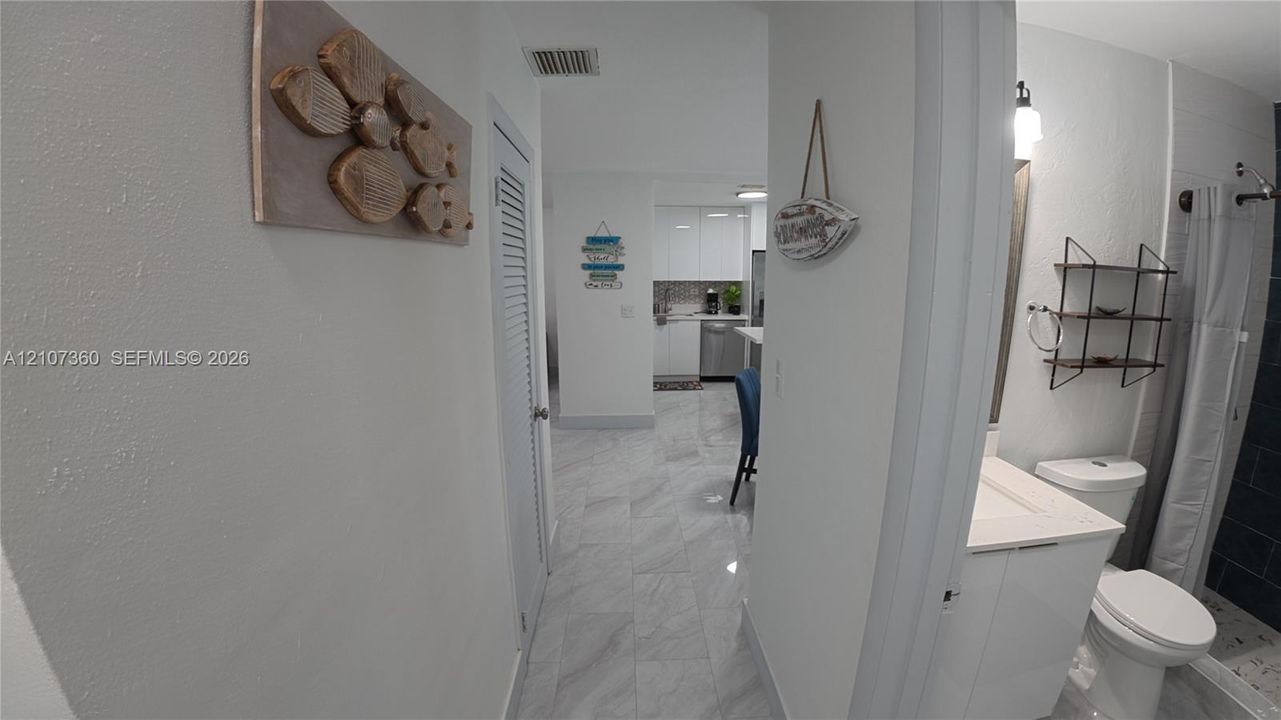 Bathroom featuring a vanity with an integrated basin, a standard-height toilet, and a tiled shower enclosure