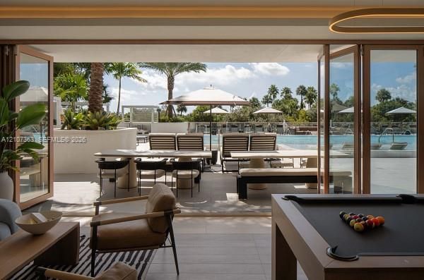 Floor-to-ceiling bi-fold glass doors, stone-tile flooring, and built-in concrete planter