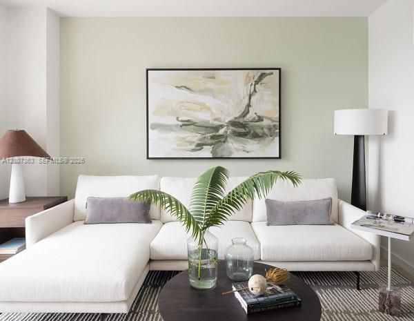 Minimalist interior space featuring a sage green accent wall and smooth, neutral-toned surfaces