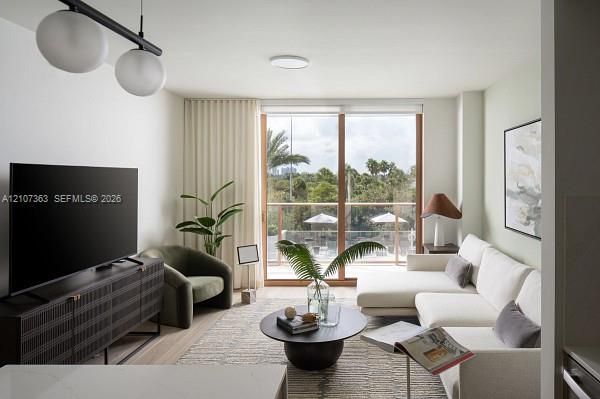 Floor-to-ceiling sliding glass doors with wood-finish frames, integrated dual-globe pendant lighting, light-tone wood-finish flooring, and recessed ceiling lighting