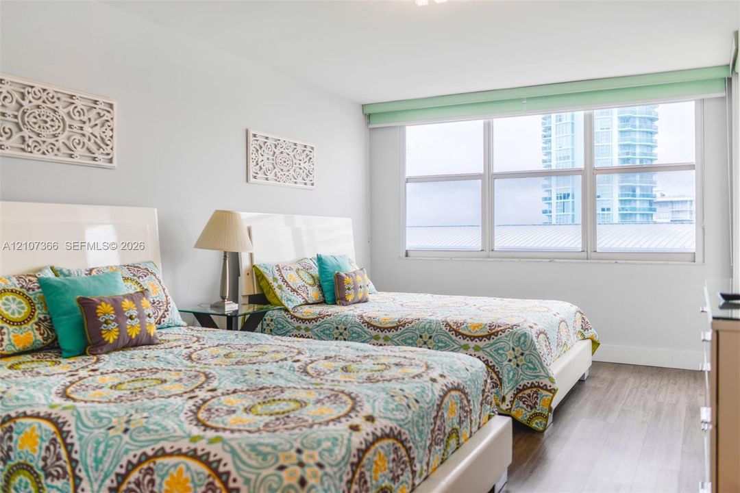 Room featuring wood-finish flooring, neutral wall tones, and large horizontal windows