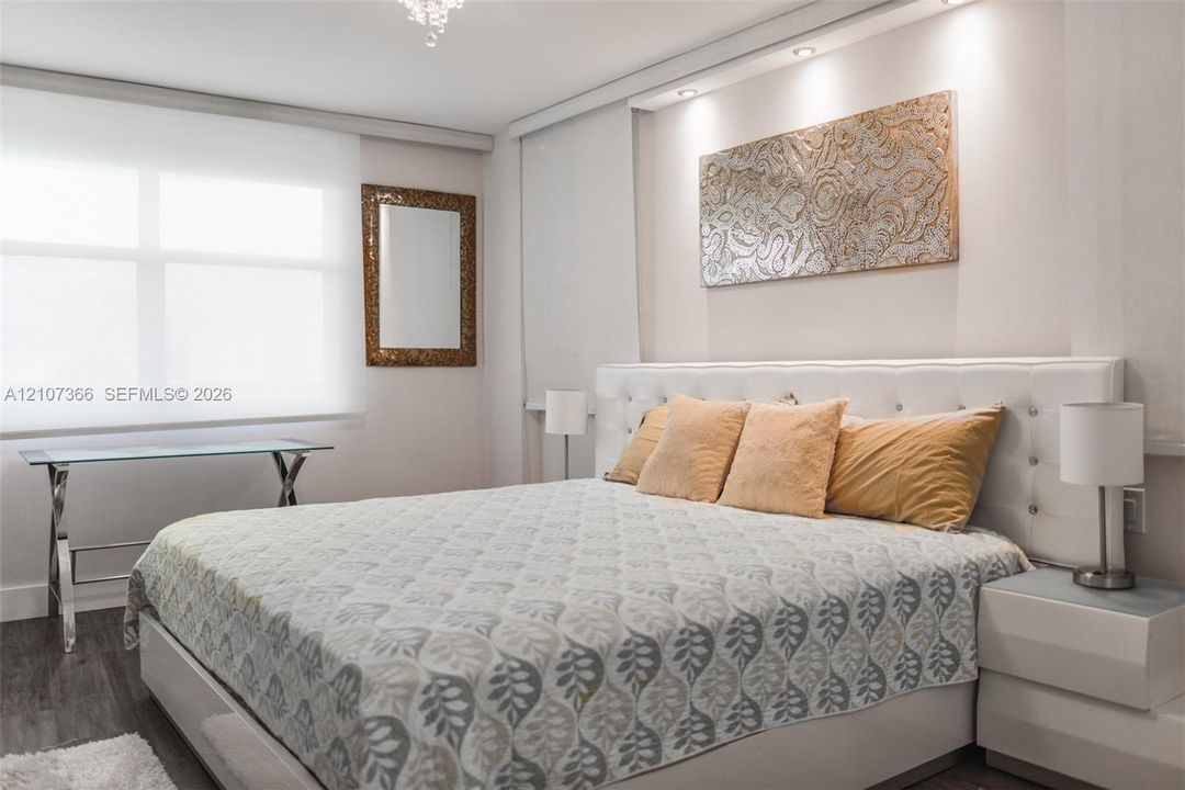 Recessed ceiling lighting, wood-finish flooring, custom wall-mounted soffit lighting, and roller shades