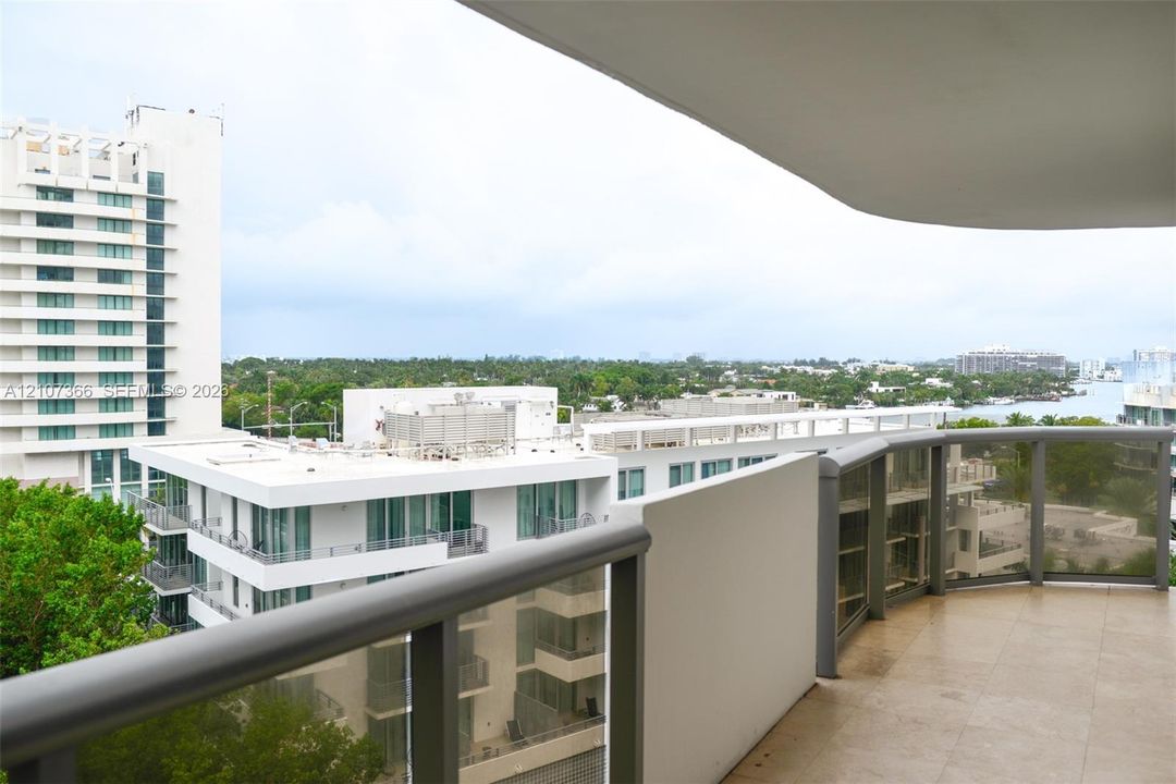 Covered balcony featuring tile flooring and metal-framed glass railings