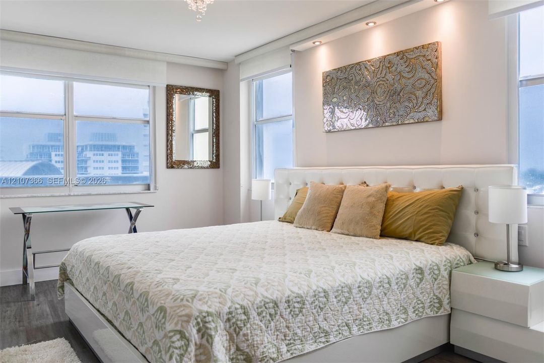 Interior space featuring wood-finish flooring, recessed ceiling lighting, and large windows with integrated roller shades
