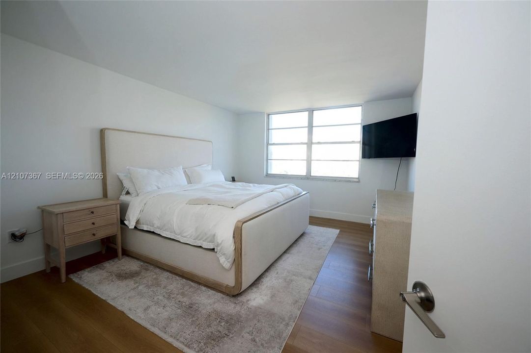 Interior space featuring wood-finish flooring and expansive windows with horizontal window panes