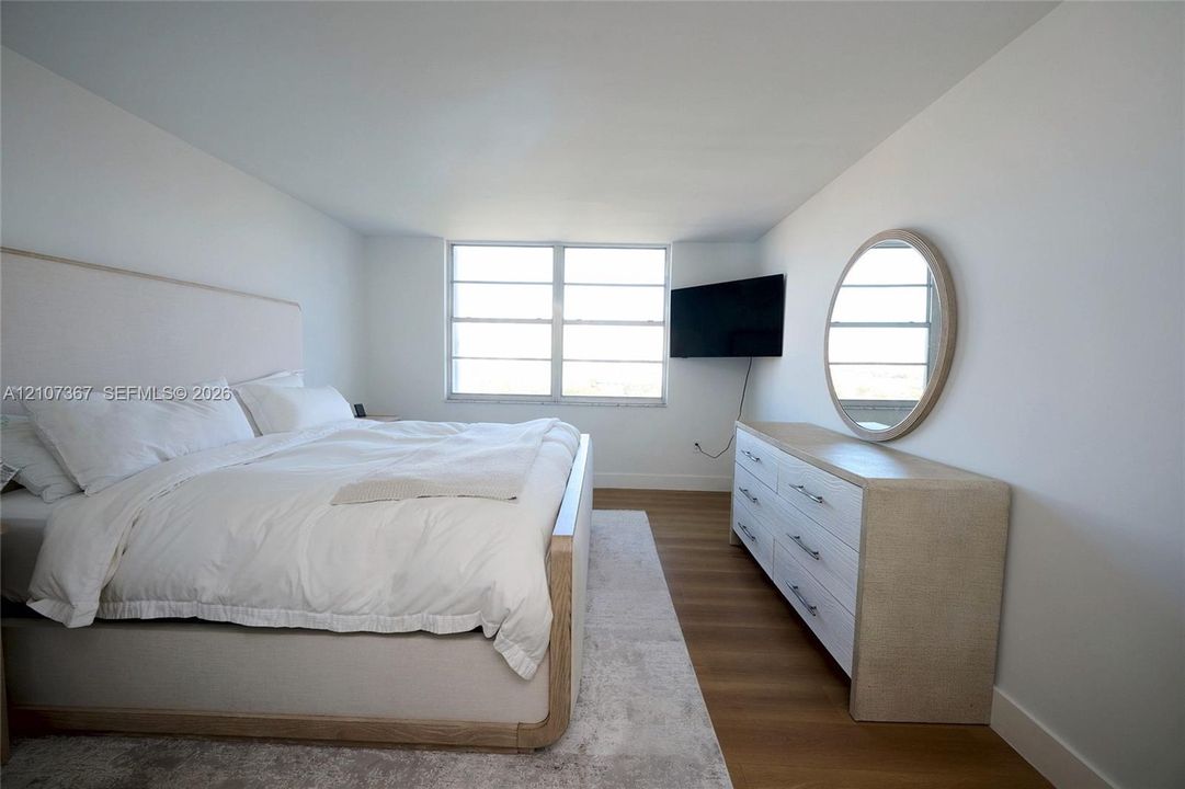 Bright room featuring large multi-pane windows and wood-finish flooring