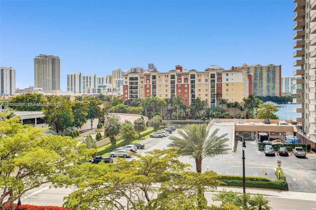 Elevated perspective featuring mature palms, manicured landscaping, and expansive urban scenery