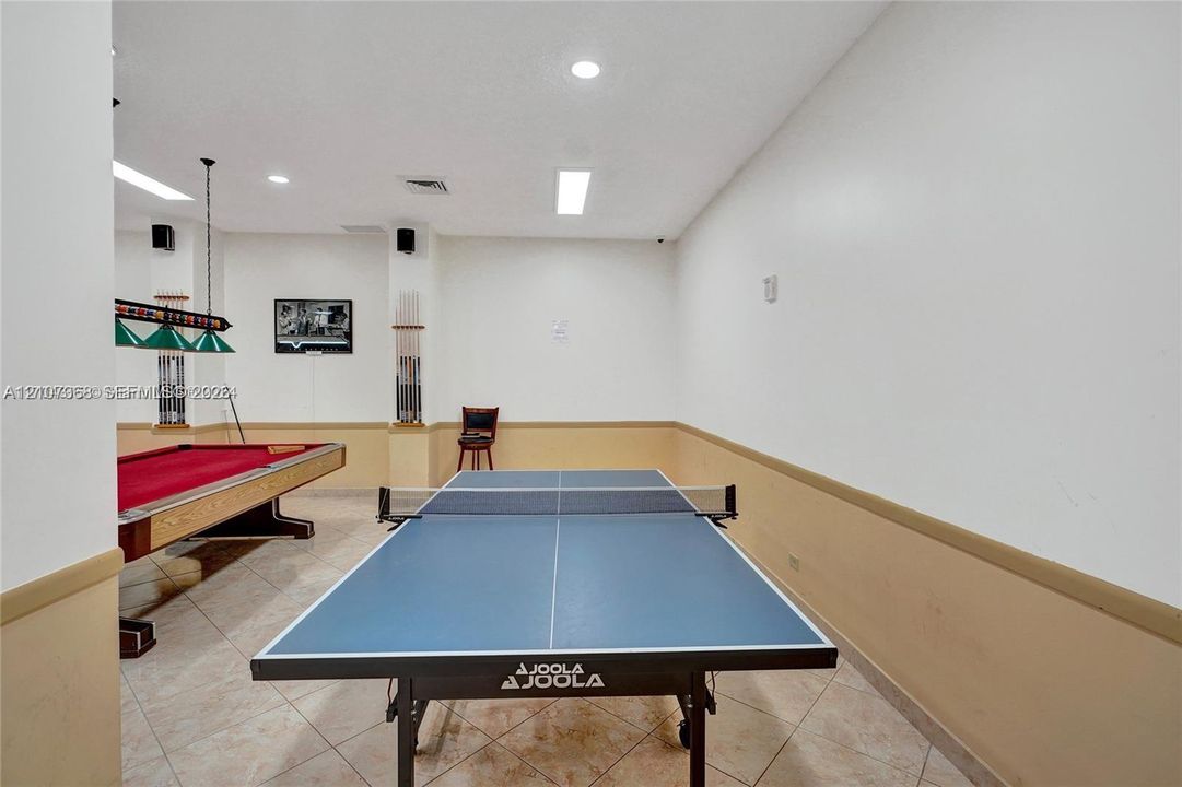 Recreation room featuring ceramic tile flooring, recessed lighting, and wall-mounted overhead task lighting