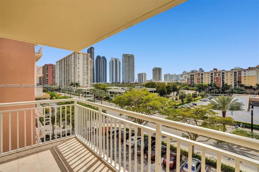 Private covered balcony featuring ceramic tile flooring and white metal railings