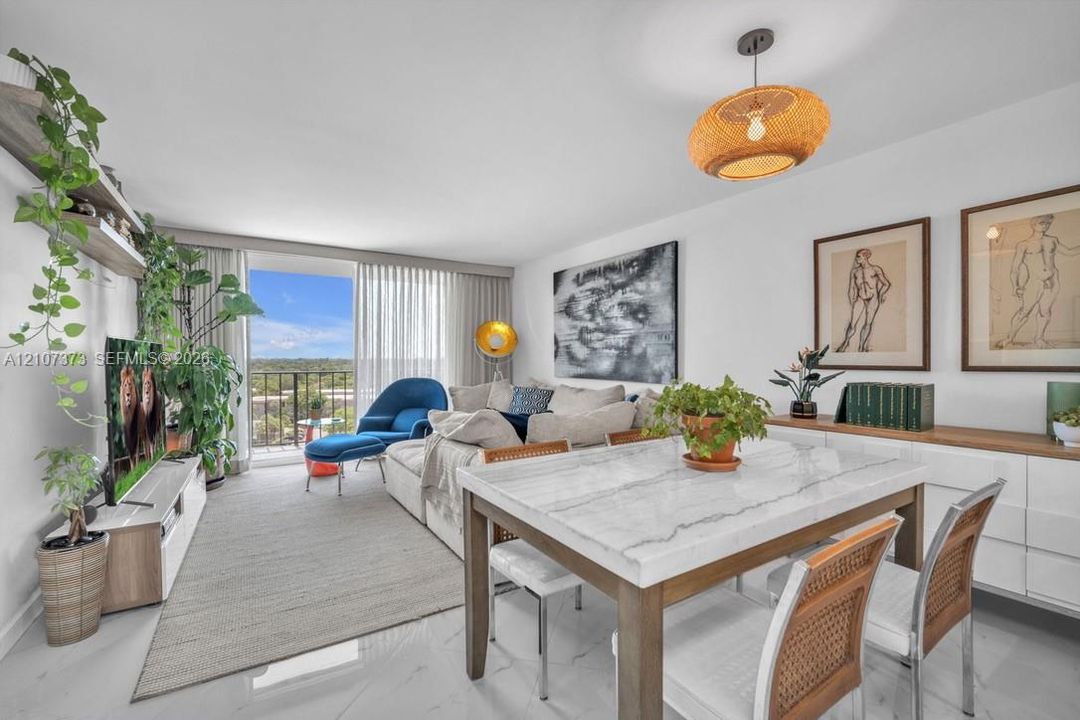 Open-concept space featuring polished stone-finish flooring, a contemporary woven pendant light fixture, and a built-in white gloss storage cabinet