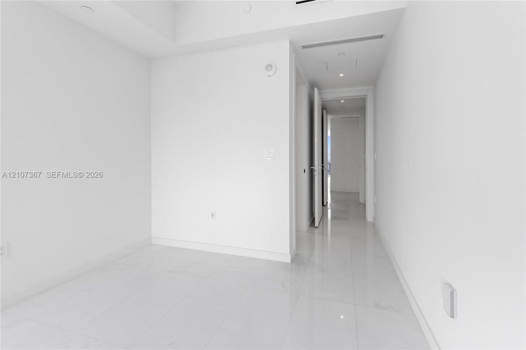 Neutral interior featuring high-gloss tile flooring, recessed ceiling lighting, and smooth-finish walls