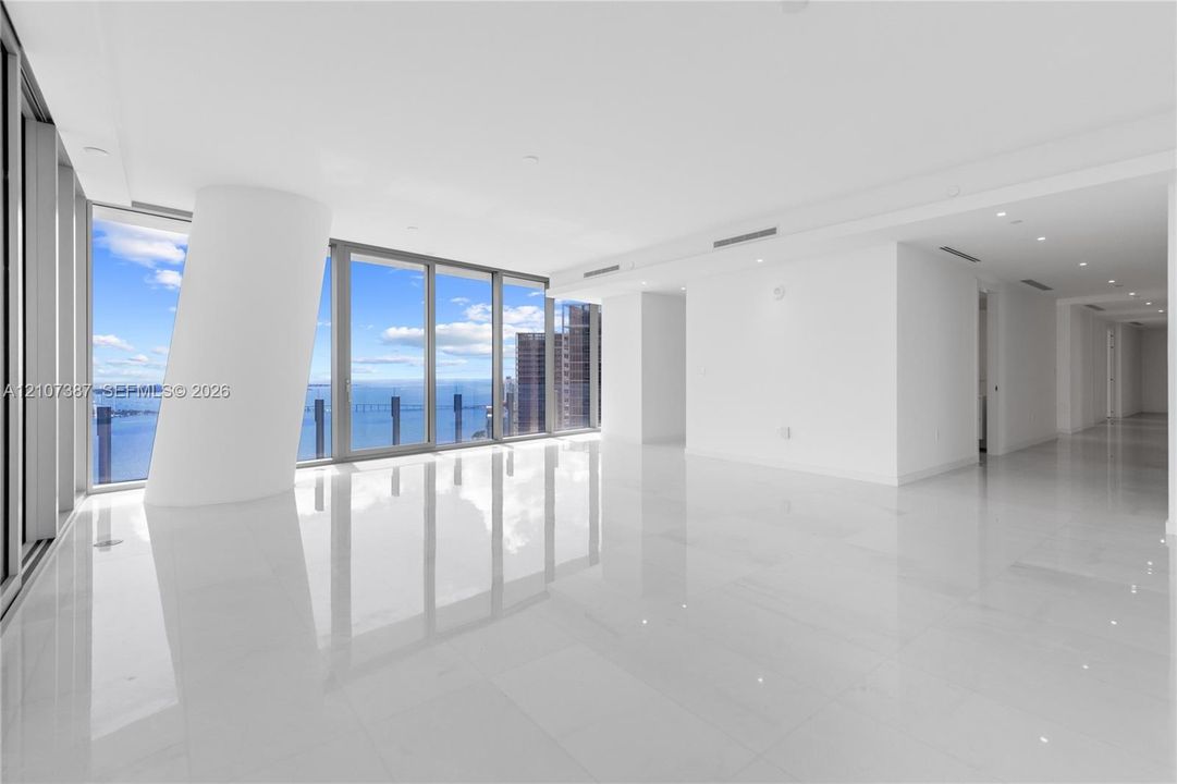 Open-concept interior featuring floor-to-ceiling glass windows, water and skyline scenery, polished tile flooring, and recessed ceiling lighting