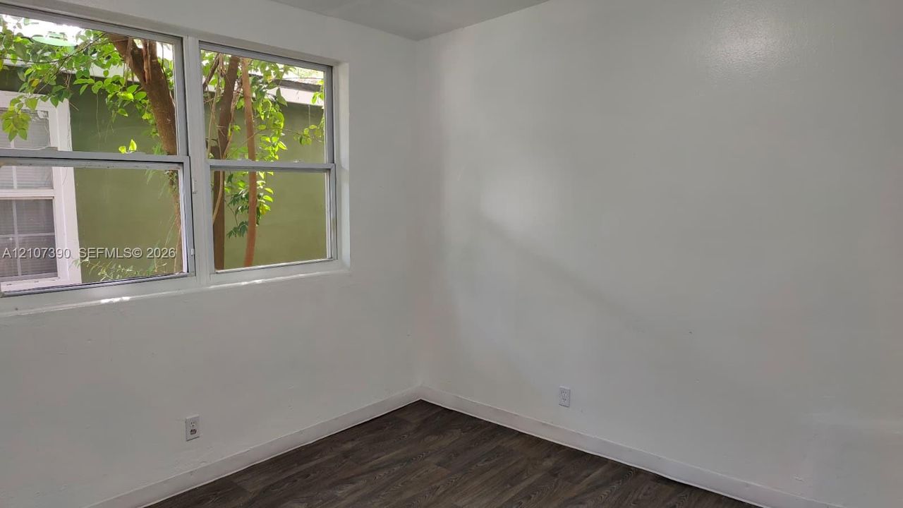 Interior space featuring neutral wall finishes, wood-finish flooring, and multi-pane windows