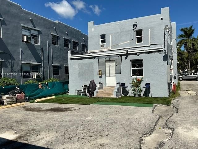 Two-story exterior featuring a stucco facade and synthetic turf lawn