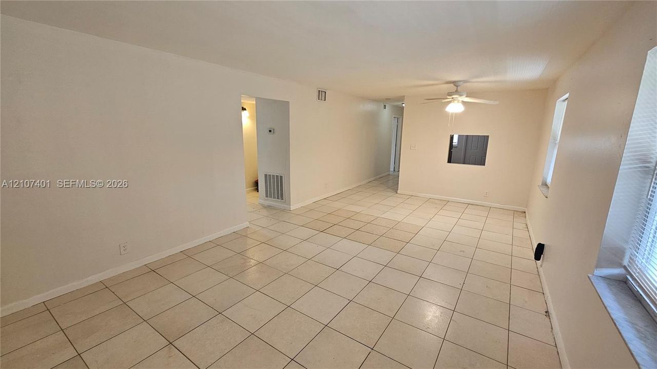 Interior room featuring neutral-toned tile flooring, recessed wall opening, and a ceiling-mounted light fixture